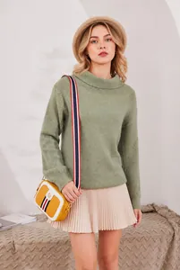 Gelbe Mini-Umhängetasche mit buntem Streifendetail getragen über einem grünen Pullover