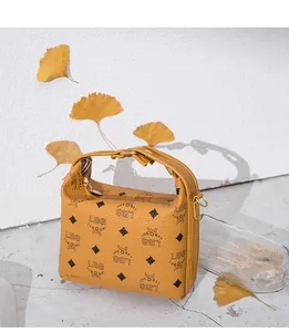Dettaglio borsa a tracolla gialla in pelle martellata con stampa e fiocco moda