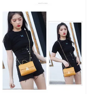 Chic yellow crocodile pattern crossbody bag with gold chain strap shown on a model