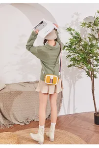 Back view of a model wearing a bright yellow crossbody bag with a striped canvas strap