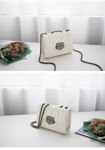 Détail du sac à bandoulière blanc matelassé avec cuir plissé et bandoulière chaîne sombre