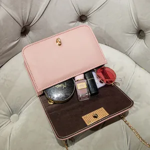 Roze gewatteerde crossbodytas met gouden ketting en draaisluiting die de binnenkant toont