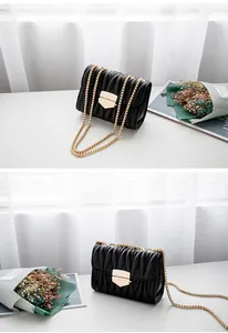 Détails de la texture matelassée noire et du fermoir doré sur le sac à bandoulière