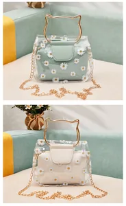 Detail of transparent daisy print bag with golden cat-ear handle and metal chain strap