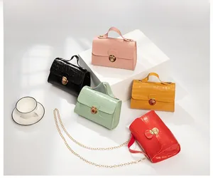 Group view of five colorful crocodile pattern mini handbags with gold chain straps