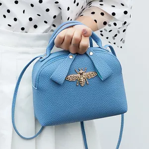 Blue lychee pattern crossbody bag with golden bee emblem and top handle for women