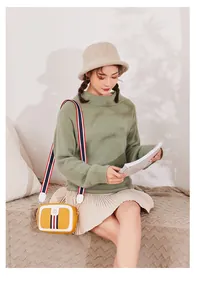 Close-up of a yellow and white crossbody bag with classic tri-color ribbon detail