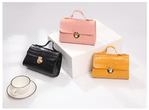 Three-color display of crocodile textured crossbody bags with gold metal clasps