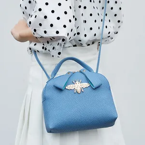 Light blue lychee texture handbag with a golden bee buckle and detachable shoulder strap