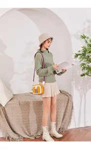 Detail of yellow rectangular crossbody bag with vibrant tricolor woven shoulder strap