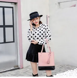 Modische rosa-schwarze Kontrast-Tote-Bag mit schickem Quastenanhänger an einem Model