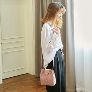 Roze bucket bag van mat PU-leer met gouden hertenhanger en trekkoordsluiting