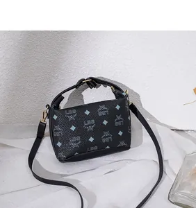 Dettaglio della borsa a tracolla in pelle nera con monogramma blu e finiture dorate