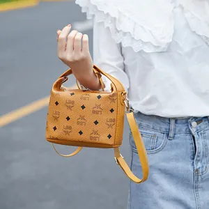 Piccola borsa a tracolla gialla senape con monogramma, manici in pelle e stile elegante