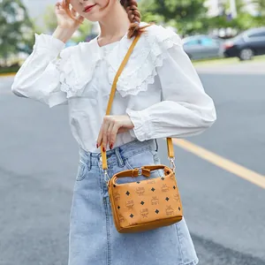 Piccola borsa quadrata giallo senape con monogramma, manico superiore e tracolla in pelle