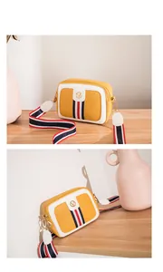 Detail view of small camera bag with colorful strap and gold V-logo hardware