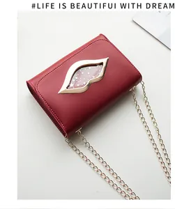 Dettaglio borsa a catena bordeaux con labbra dorate e glitter a forma di stella