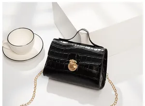 Close-up of black crocodile pattern chain bag featuring a round golden metal lock buckle