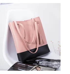 Detailansicht der schicken rosa-schwarzen Totebag mit Quaste auf einem weißen Stuhl