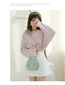 On-body view of mint green hexagonal crossbody bag with yellow stitching and metal lock