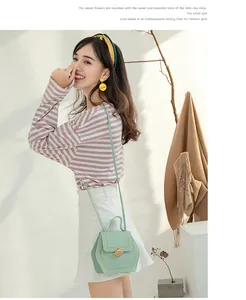 Detail showing mint green hexagonal bag with contrast stitching and gold metal twist lock