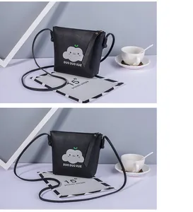 Dettaglio di una mini borsa a tracolla nera con motivo a nuvola su uno sfondo lifestyle