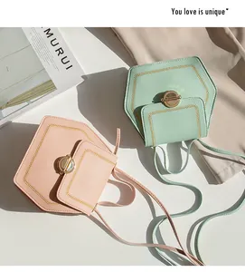 Flat lay of hexagonal crossbody bags with gold chain trim and litchi texture