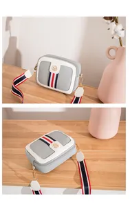 Detail of grey lychee leather camera bag with tricolor stripes and golden logo
