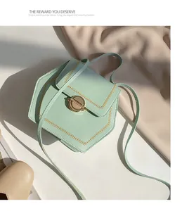 Detail of mint green leather crossbody bag with gold hexagonal lock and fine stitching