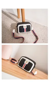 Detail of crossbody camera bag with contrast stitching and tricolor striped shoulder strap