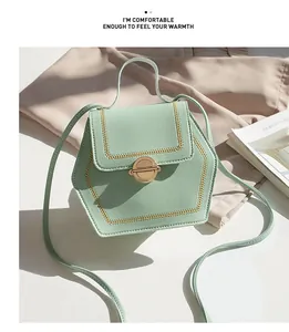 Detail of mint green hexagonal crossbody bag with gold lock and chain stitching