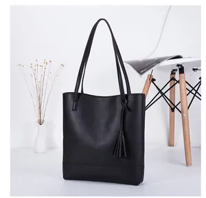 Minimalistische schwarze PU-Leder-Einkaufstasche mit Quasten in stilvoller Wohnumgebung