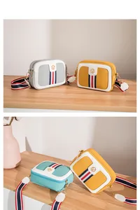 Detail of color-block camera bag with lychee leather texture and wide striped strap