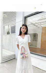Détail du sac seau transparent à marguerites avec foulard et bandoulière dorée