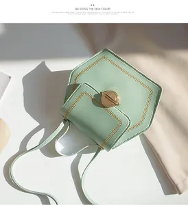 Detail of mint green geometric crossbody bag with gold circular lock and stitching