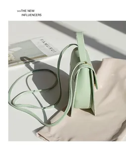 Detail of mint green mini square bag with hexagonal lock and accordion side folds