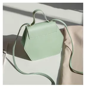 Detail of light green hexagonal crossbody bag with premium stitching and gold hardware