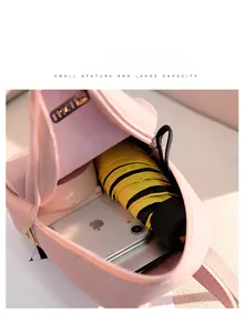 Detailed interior of a pink compact backpack showing space for an umbrella and phone