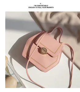 Detail of pink geometric crossbody bag featuring gold wheat-style stitching and rotary lock