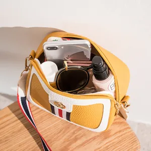 Chic mustard yellow crossbody camera bag with ribbon decor showing daily item capacity