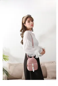 Mini pink women's backpack featuring stylish color-block design and golden bow buckle