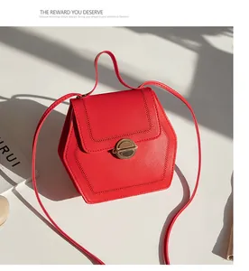 Detail of red hexagonal handbag with fine stitching and golden circular twist lock closure