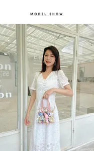Détail du sac seau transparent en PVC avec imprimé marguerite, foulard en soie et pochette