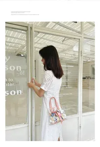 Détail du sac seau en PVC transparent avec insert en paille, perles et foulard en soie