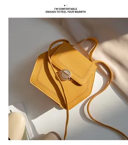 Artistic view of a yellow hexagonal crossbody bag with grain texture and metal lock
