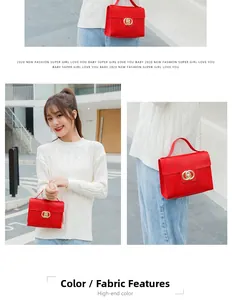 Close-up of red embossed leather handbag featuring golden double ring interlocking clasp detail
