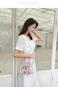 Détail du sac seau transparent à marguerites avec insert en paille et foulard en soie
