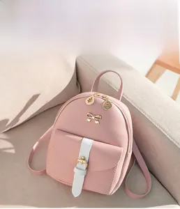 Detail of pink PU leather mini backpack with golden bow and leaf-shaped metal zippers