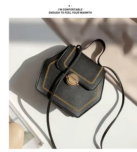 Close-up of black pentagonal crossbody bag with golden weaving and round buckle