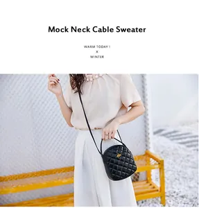 Close-up of black quilted round crossbody bag with golden bee emblem and leather handle